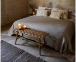 Banco de madera de roble a los pies de una cama de matrimonio