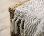 Detalle de plaid de sofá con flecos 100% algodón beige
